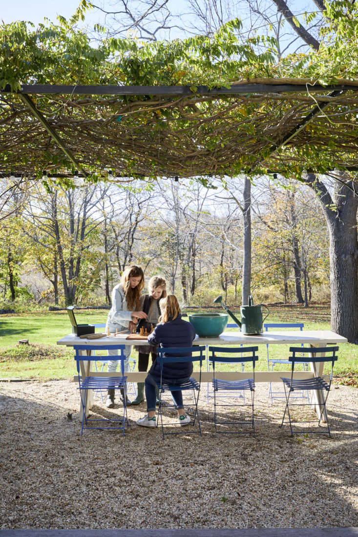 french doors in the back of the house open to a gravel patio shaded by a wister 29