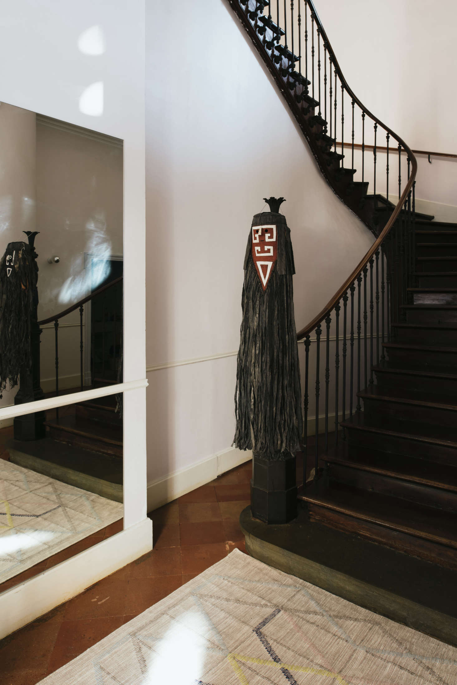 Hanging from the banister is a Tamok mask. 
