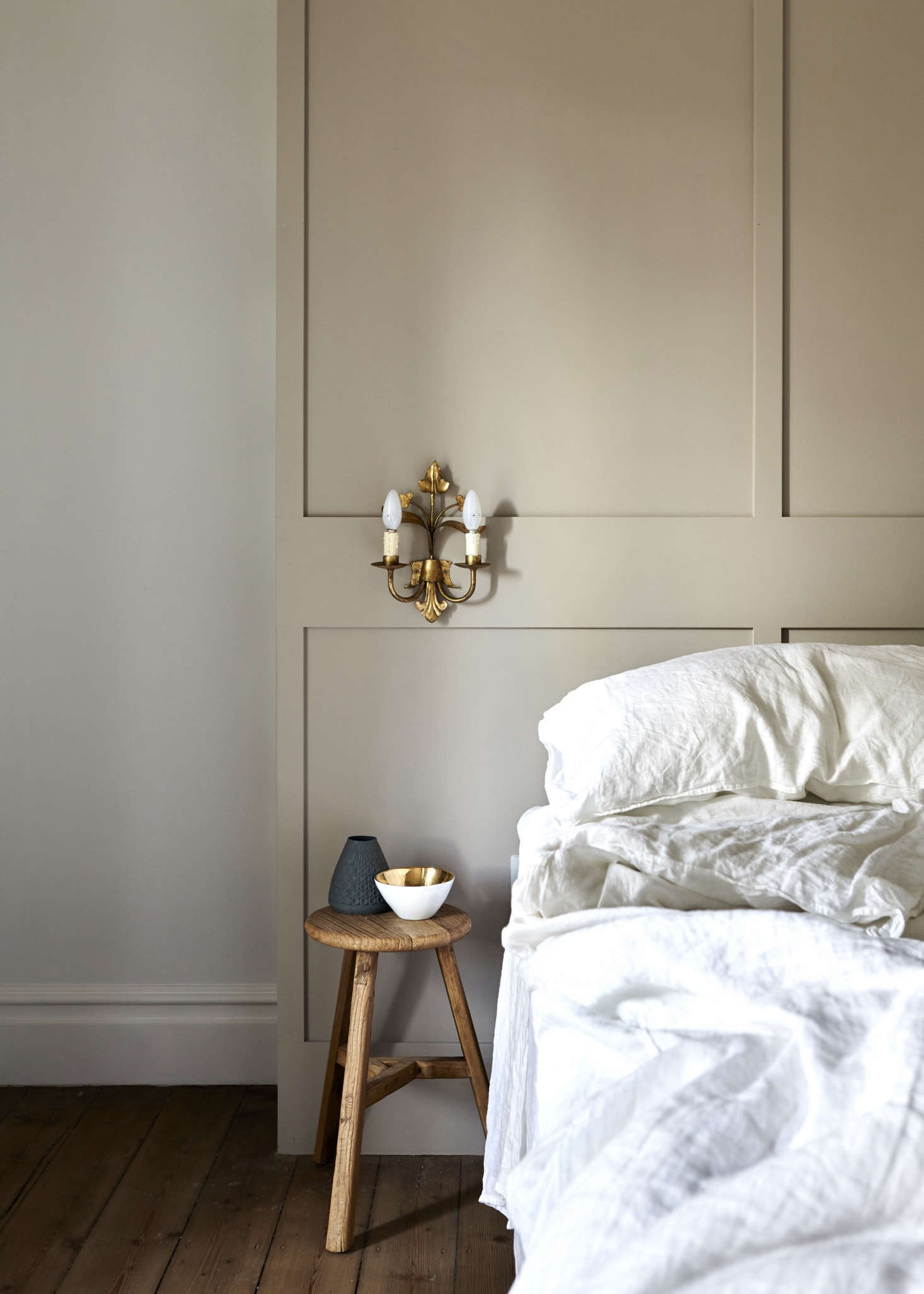 In place of a fireplace, the master bedroom has a floor-to-ceiling paneled headboard, which has shelves concealed on the sides. 