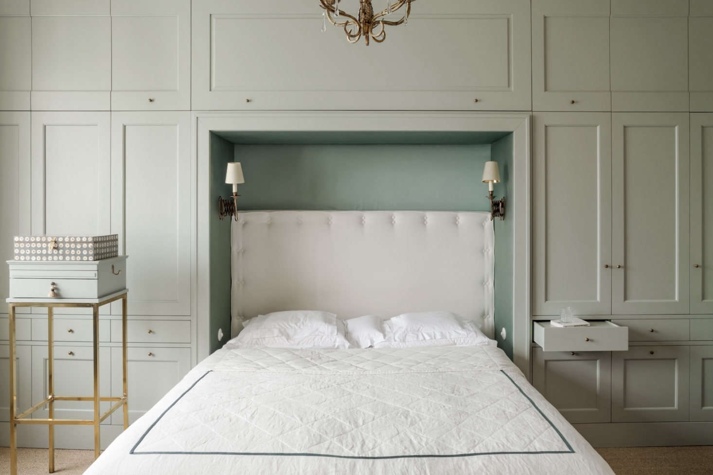 To add much-needed storage in the bedroom, Chrapka designed a wall of built-ins, painted in Farrow & Ball