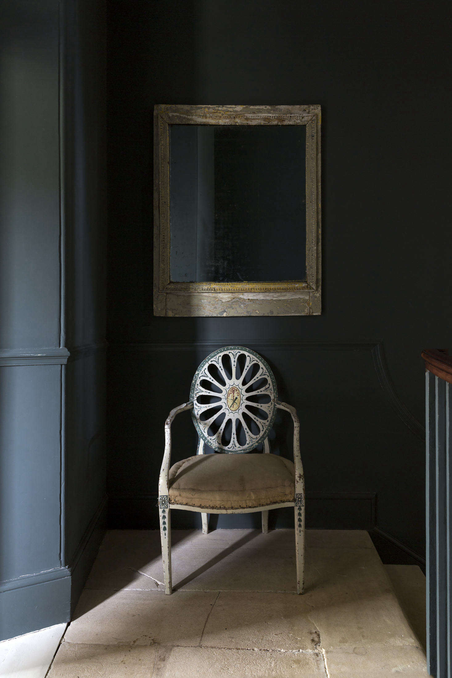 A painted Hepplewhite chair stands on the half landing between the first and second floors