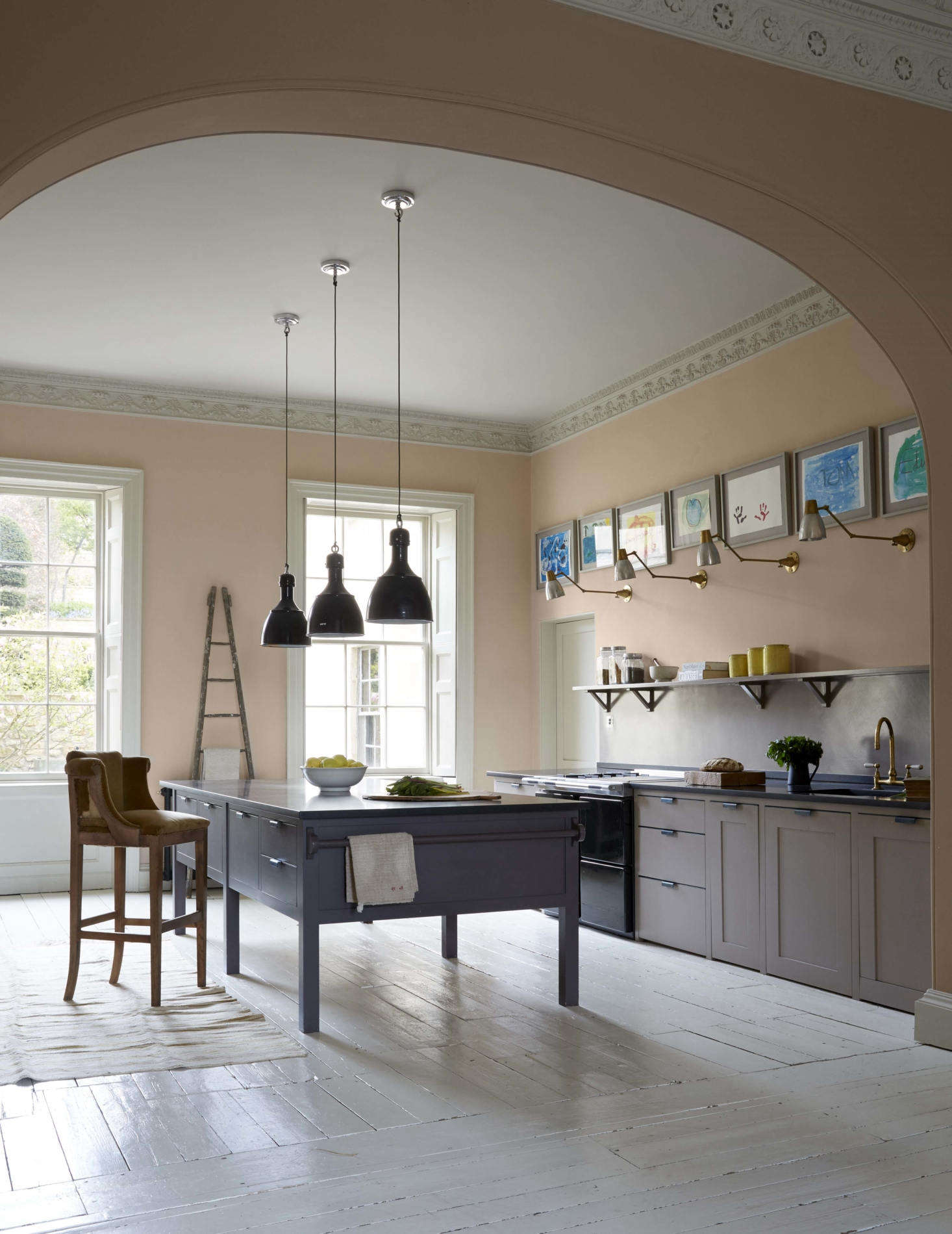 The ballroom-scaled kitchen is fitted with a work island and cabinets from Plain English, which straddle the line between classic and contemporary. The walls are painted Setting Plaster, a Farrow & Ball pale pink that Harding says is her favorite color to live with: 