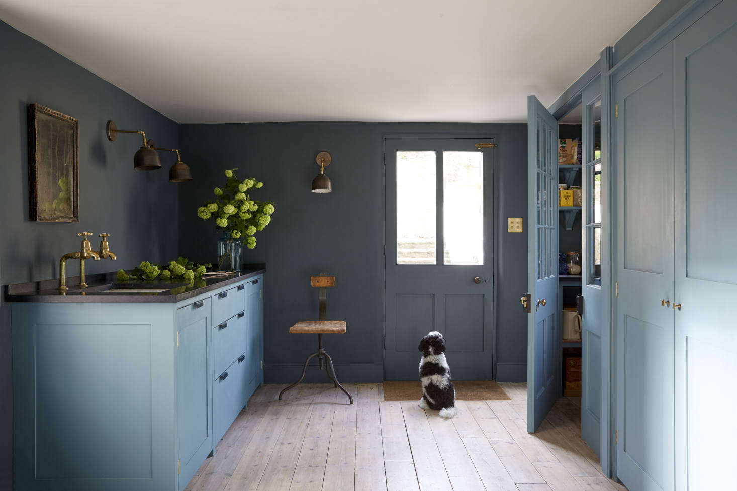 The breakfast table blue, Blue Gum, reappears in the Plain English-furnished pantry offset by walls in Squid Ink (both colors are from Paint & Paper Library). The back door leads to the garden.