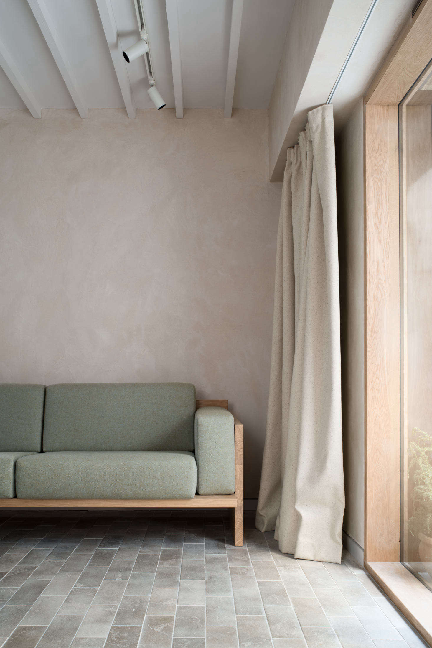 Heavy canvas curtains can be pulled across the entrance. The couple finished the walls with clay plaster from Clayworks to enhance the light, regulate humidity levels, and create a surface so nuanced there