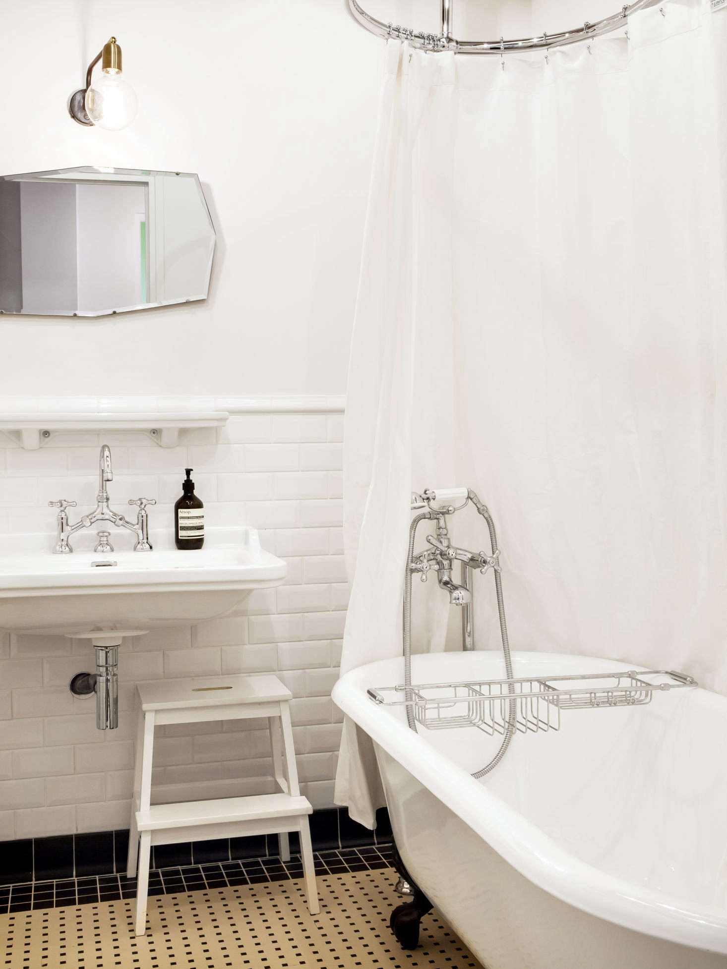 Designed back when the family first moved into the building, the bathroom has a tile rug, a polished nickel bridge faucet, and walls in lined in metro tiles—beveled subway tiles. Thinking of installing your own freestanding tub? See Things Nobody Tells You About Clawfoot Bathtubs.