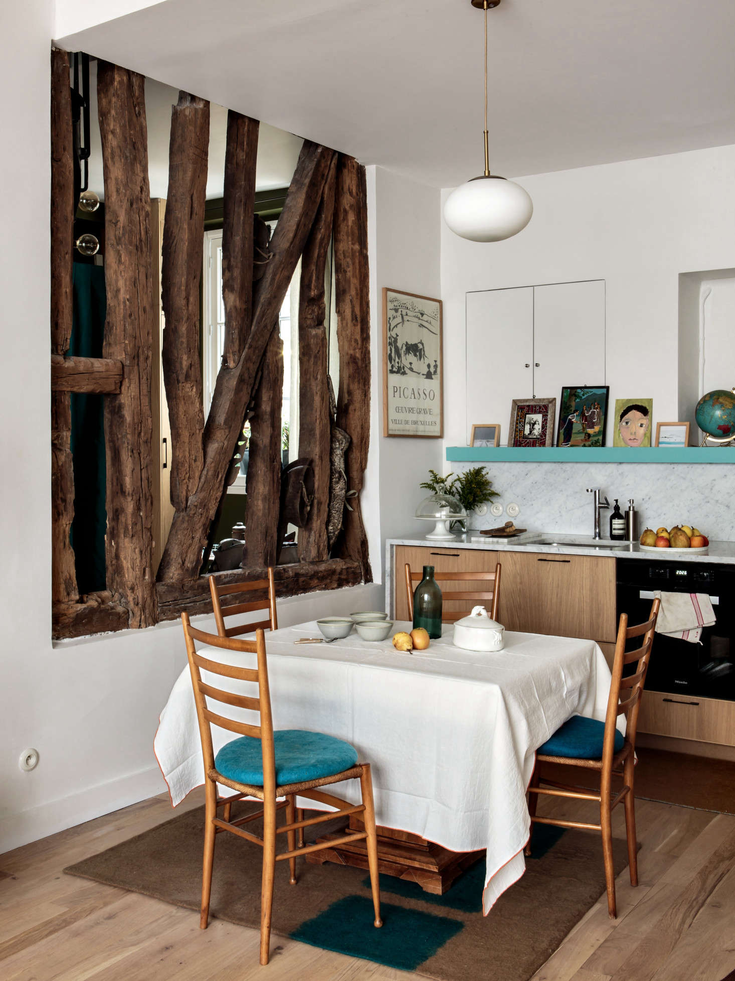 To maximize the light, Hermand inserted a number of inventive interior windows throughout the duplex. Here she exposed the wall timbers to create a screen that divides the living space from the entry.