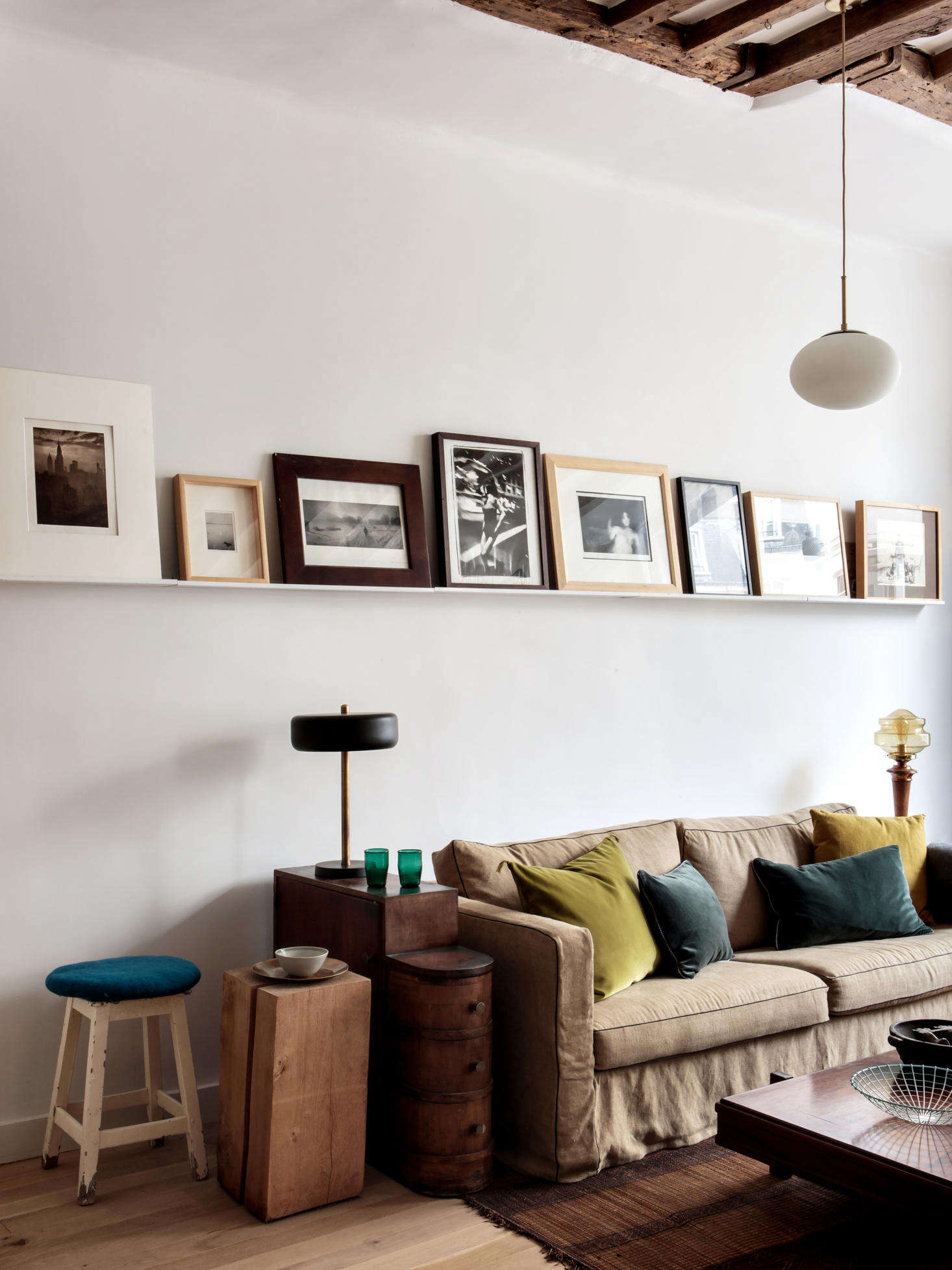 A gallery shelf displays black-and-white photos in a range of simple frames inexpensively sourced from Fleux. For side tables, Hermand goes with a mix, including an old stool. The rug is a classic Tuareg mat of straw and leather (see New Directions: Design Trends for ).