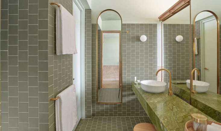 a monochrome green bathroom in a city view room. note the mirror on tracks at r 22