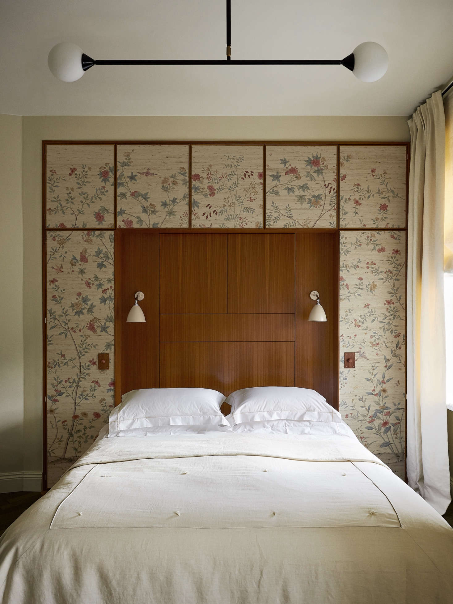 A quirk of the apartment is that nearly every room has a diagonal wall. In the bedroom, Chrapka straightened the room with the help of a built-in headboard and cabinet. The Bestlite sconces are by Gubi.
