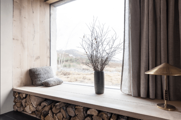 The interiors are clad in Danish oak which, here, forms a low window seat for looking out at the moors; firewood, all cut from the grounds, is stacked beneath.