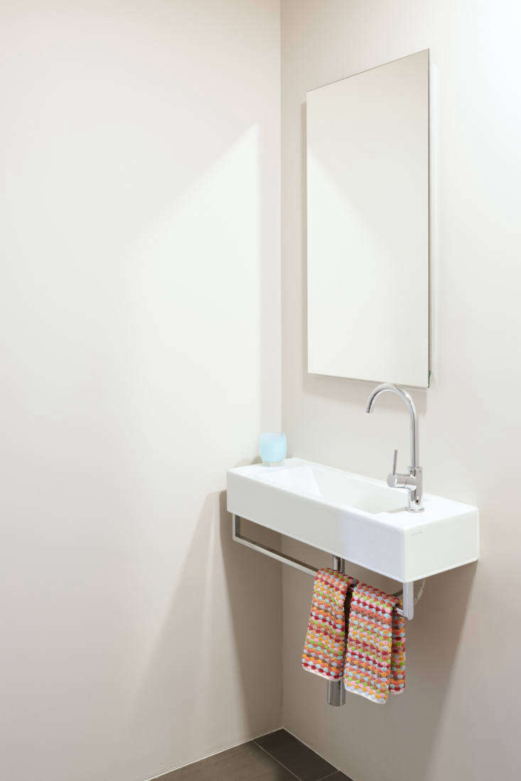 the powder room&#8\2\17;s slim, wall mounted sink with towel bar is an alap 24