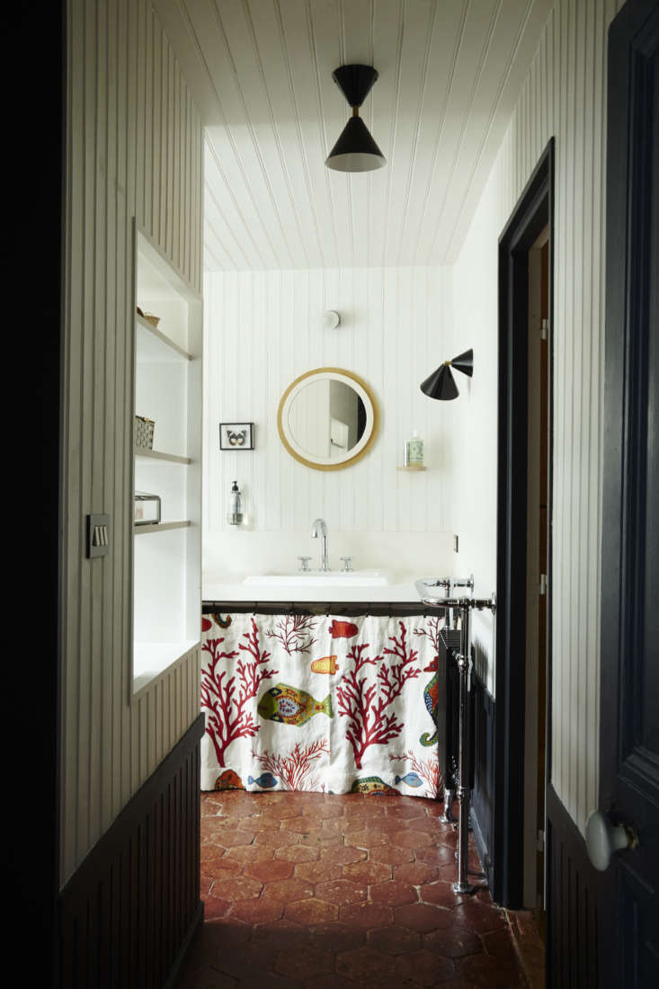 in the master bathroom, a paneled wall with cut out shelving divides the sink a 28