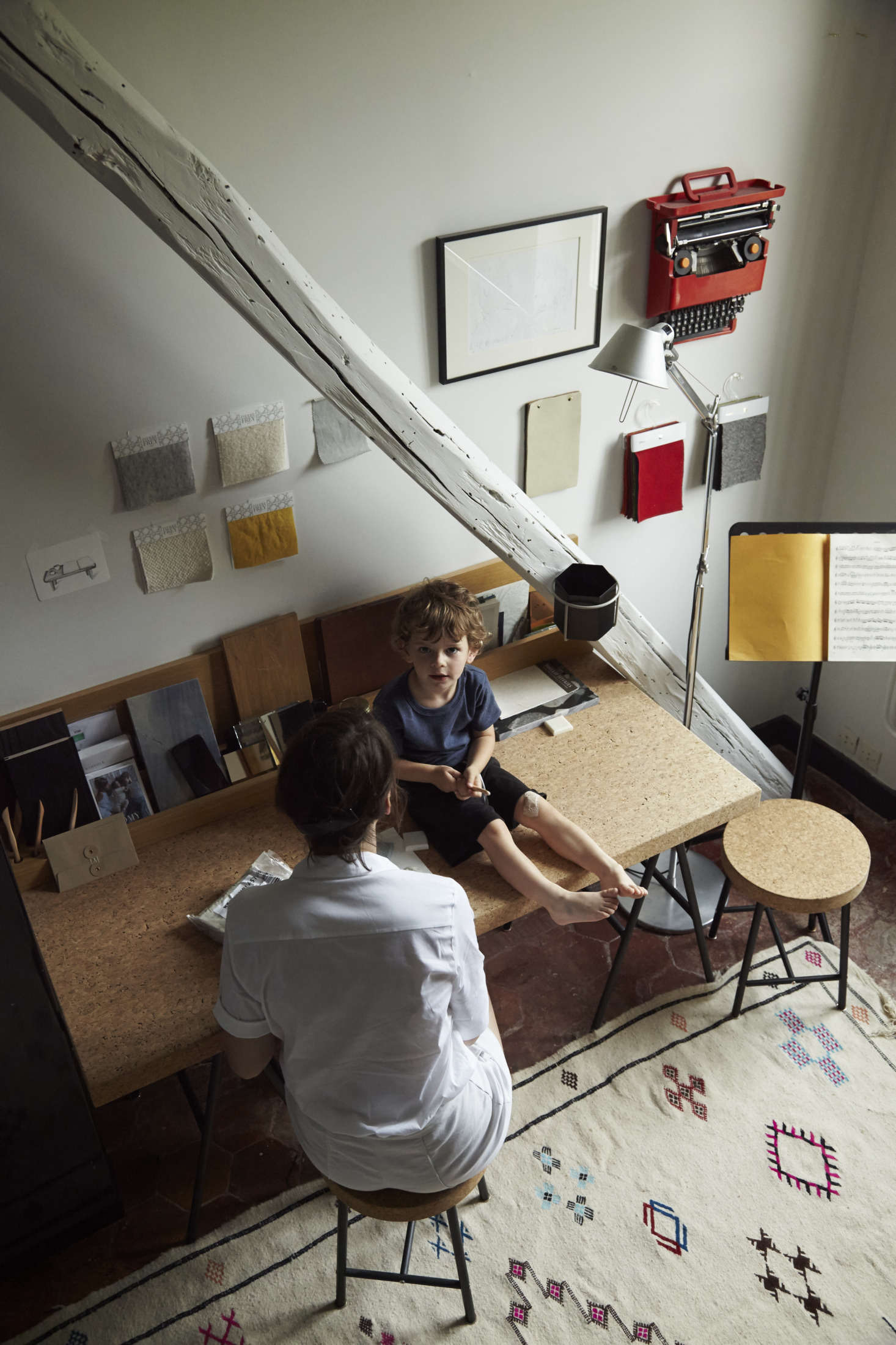 Designer Gesa Hansen is a pro at mixing high and low. Here in her office, she paired a cork-topped table and stools from Ikea with the Tolomeo Floor Lamp, a modern classic. Photograph by Nathalie Mohadjer, courtesy of Gesa Hansen, from Gesa Hansen