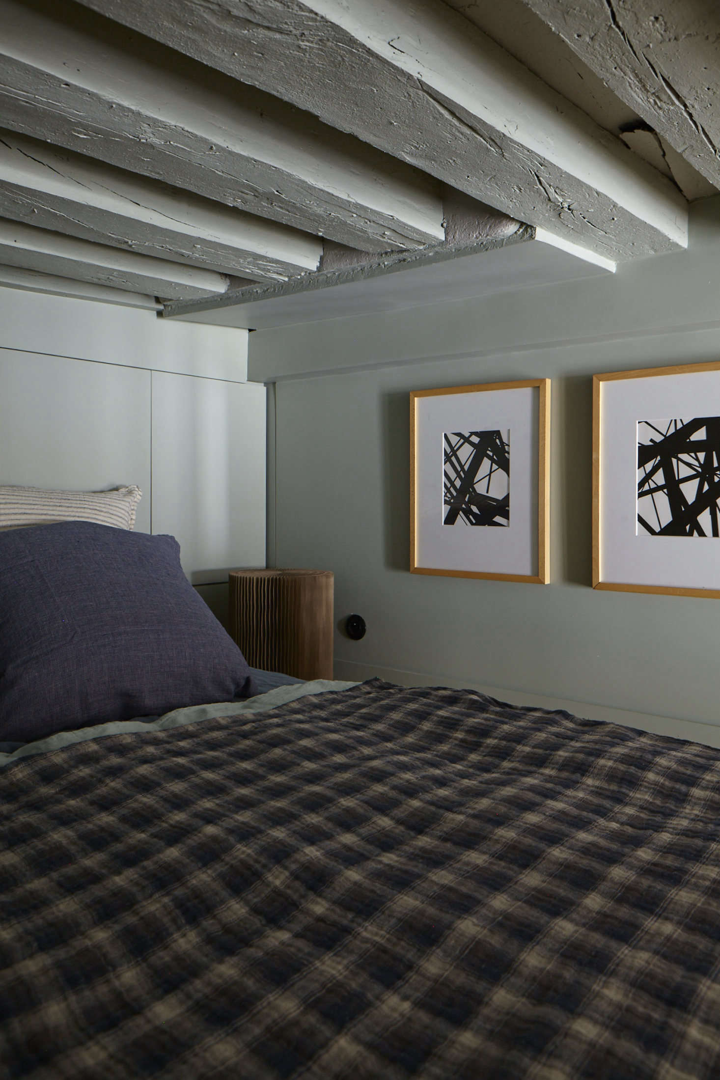 Evennou embraced the tininess of the upstairs sleeping loft, painting walls, ceiling, and beams alike in a pale green.