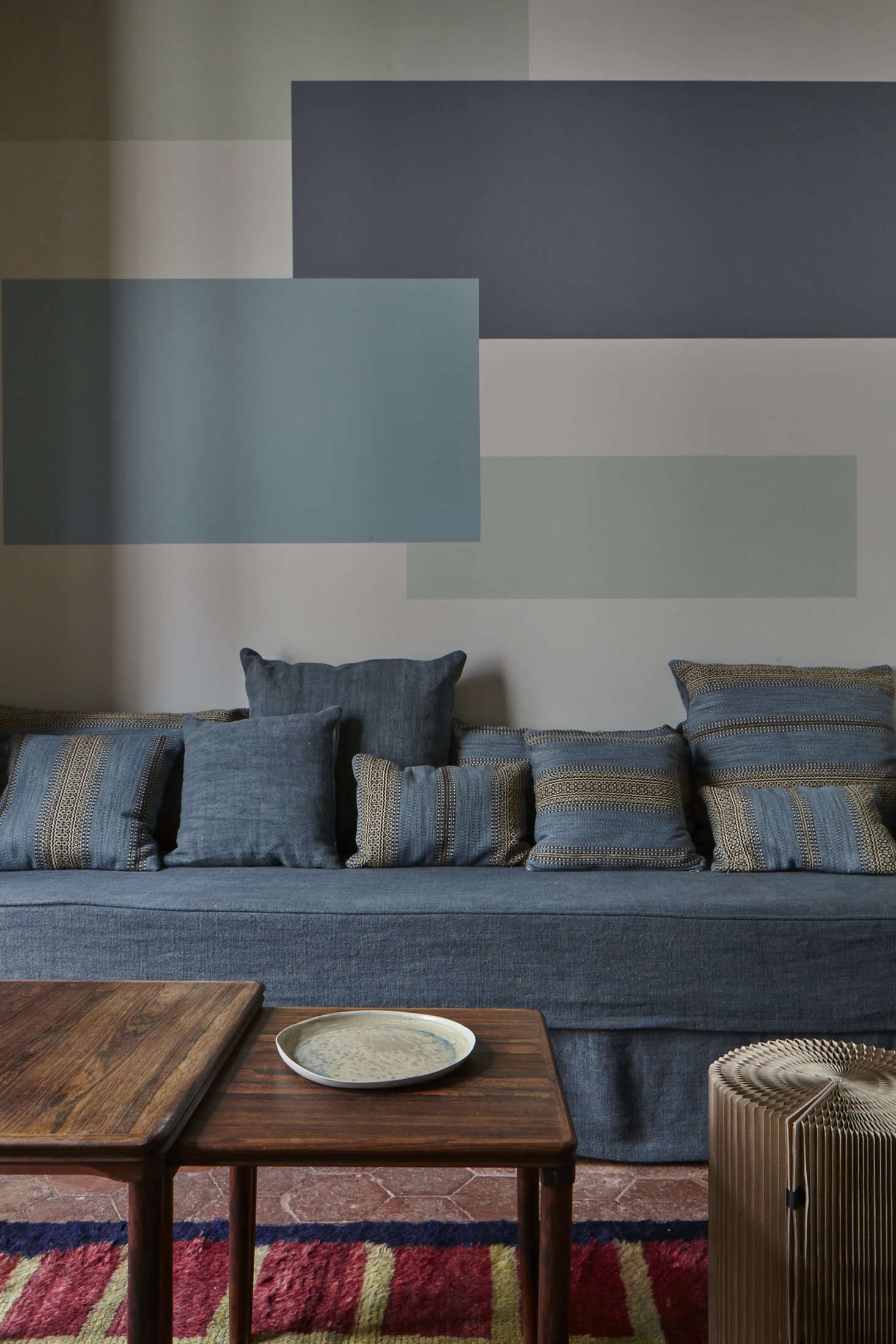 The graphic mural behind the couch sets apart the living area. The idea, Evennou says, is 