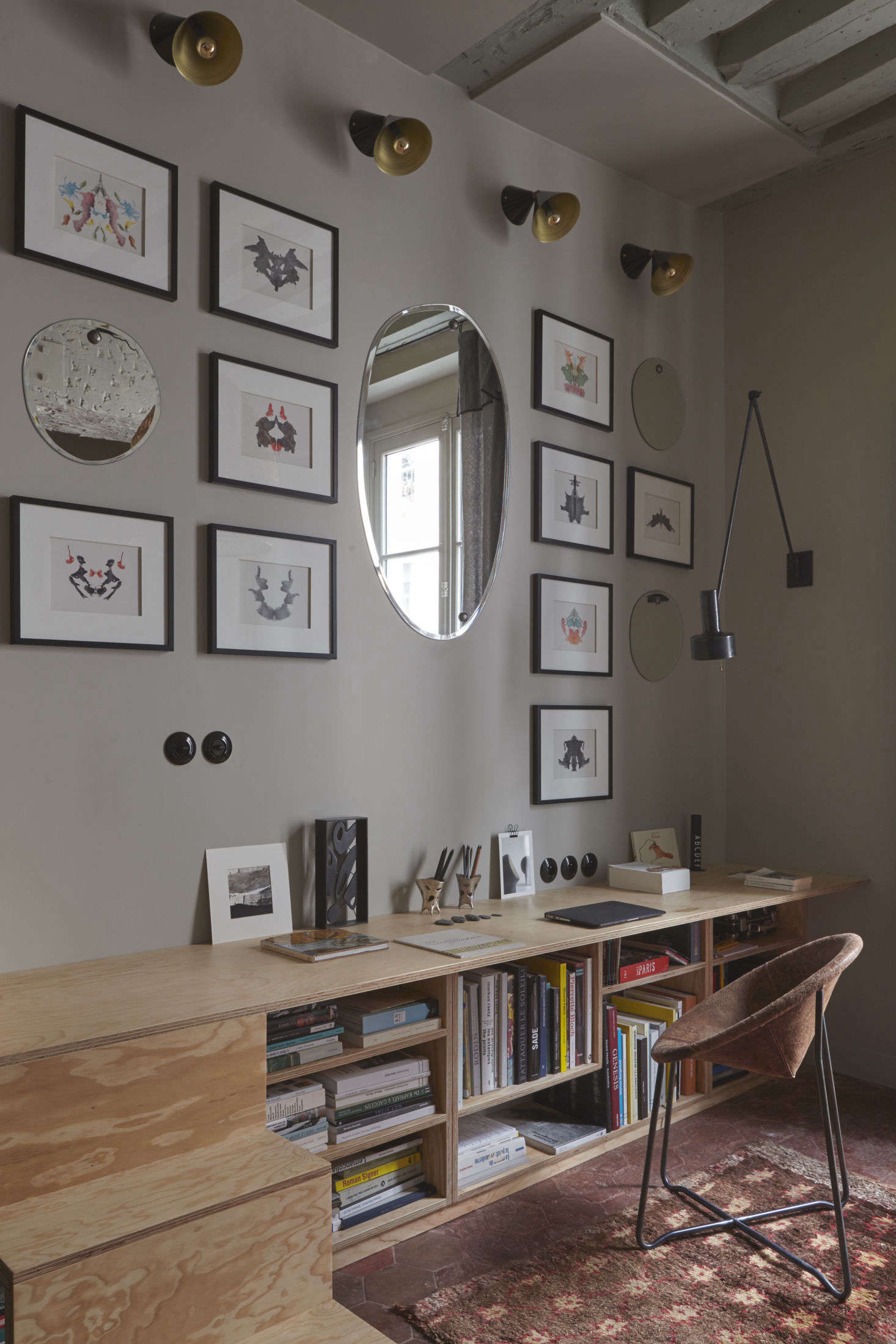 The unit continues into low bookshelves and a simple desk. The irregular oval mirrors throughout, which help to bring in light and the illusion of more space, are the Morning Mirrors from M Nuance.