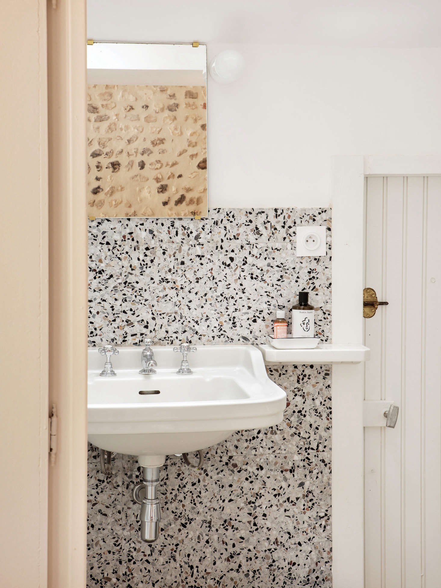 Italian terrazzo tiles from Palatino paired with an original sink and paneled door.