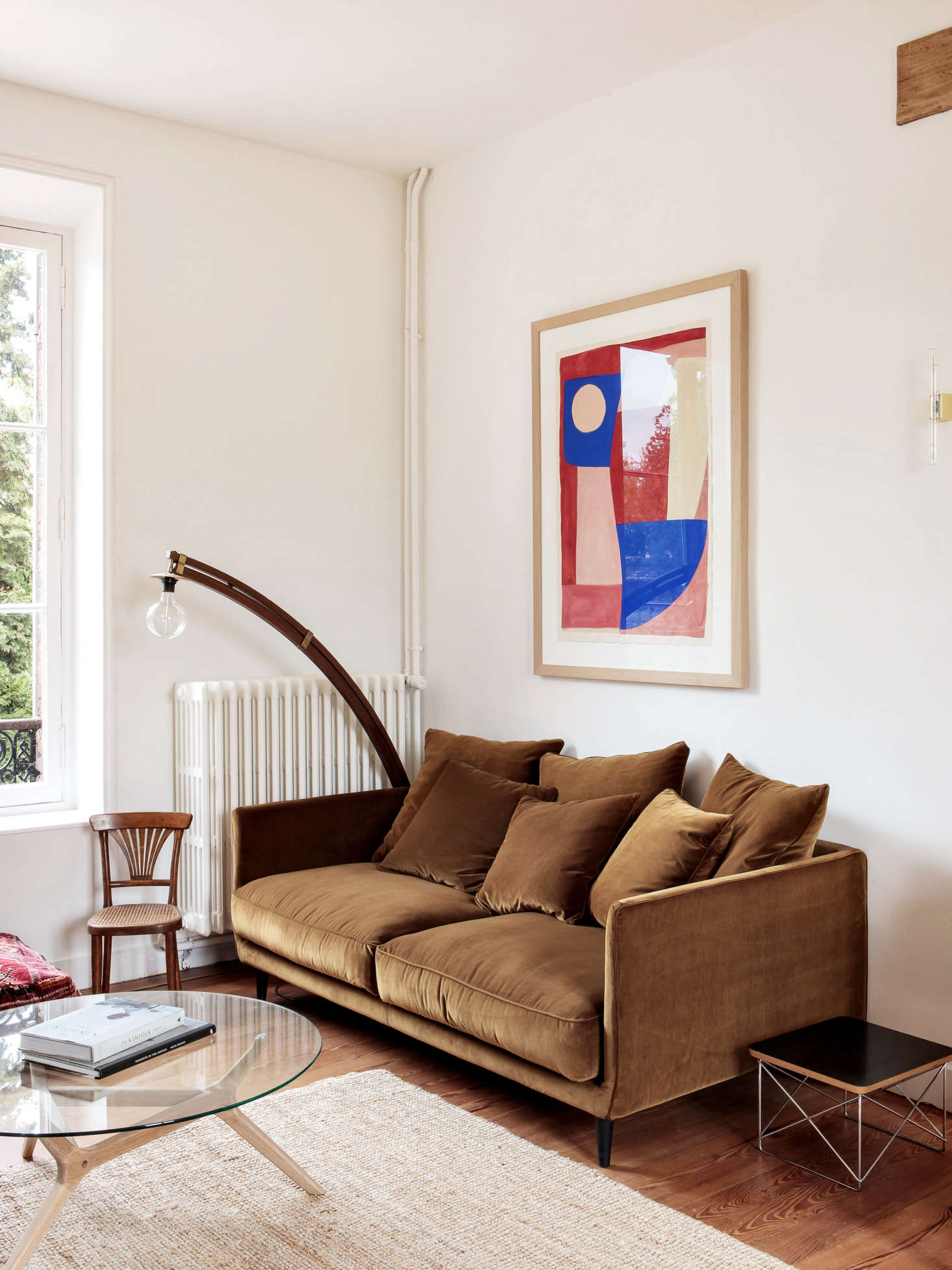 A painting by Caroline Denervaud hangs over another AM.PM sofa.