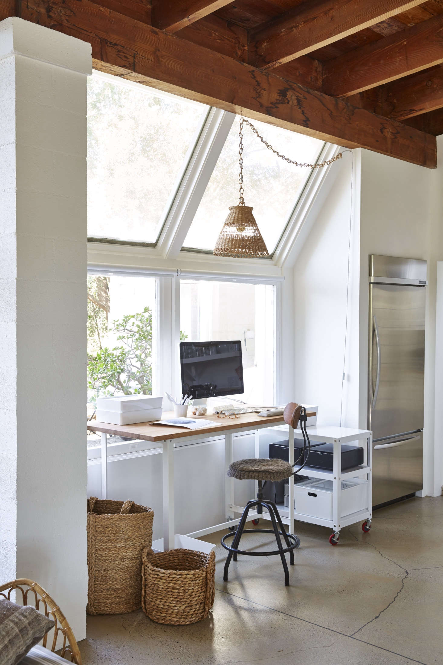 A slim workspace, with a clean-lined desk and stool, fits next to the KitchenAid fridge, along with a low credenza on wheels for easy transportation while shooting.