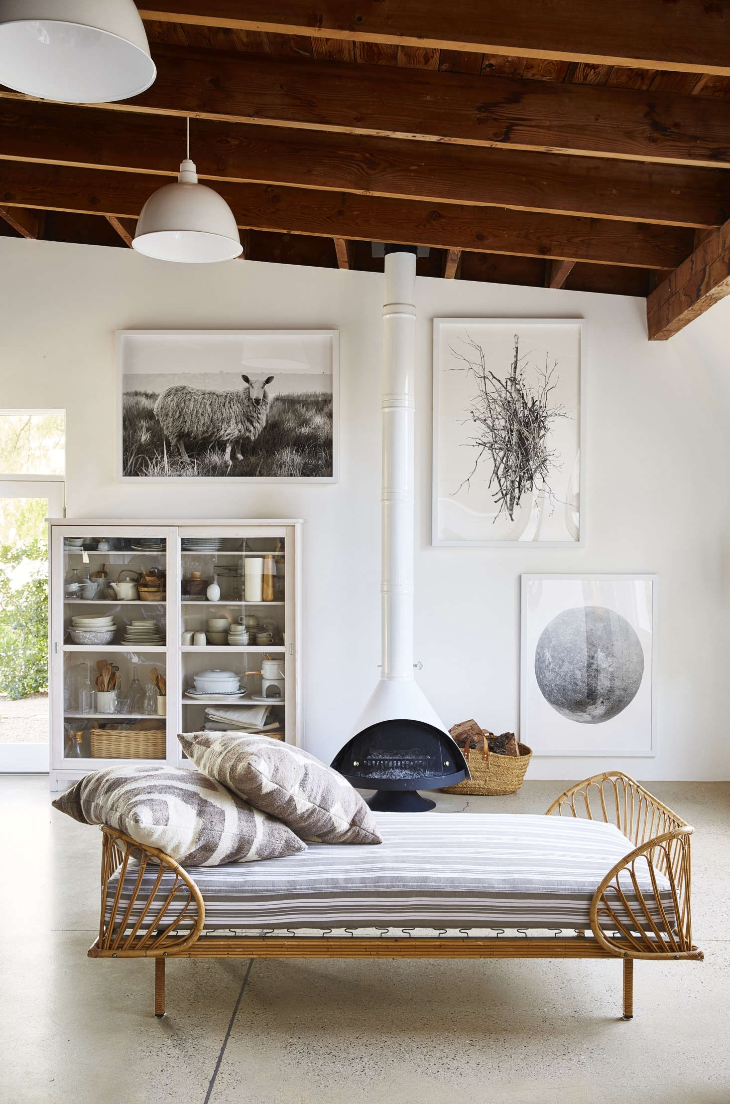 Case in point: An open lounge area is kept sparse, with a glass cabinet serving as storage for more props, and a low daybed from Elsie Green. 