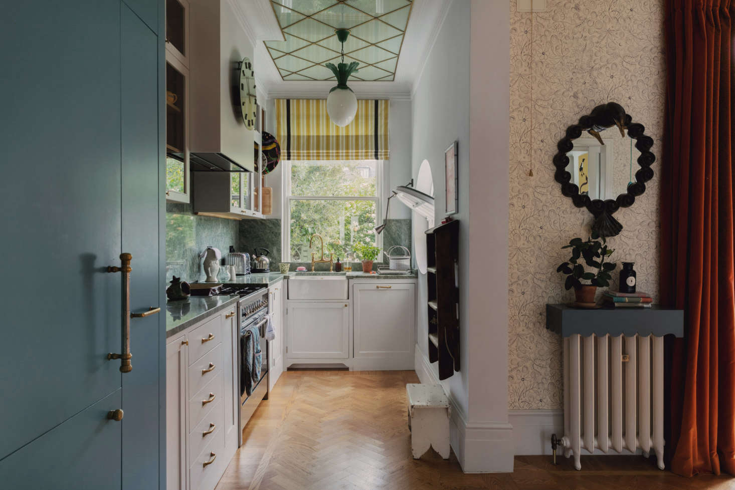 Because the dining room is attached to the kitchen, Heuman disguised the refrigerator (at left) as a blue armoire. The kitchen is tiny but efficient and organized (note the hanging step ladder). 