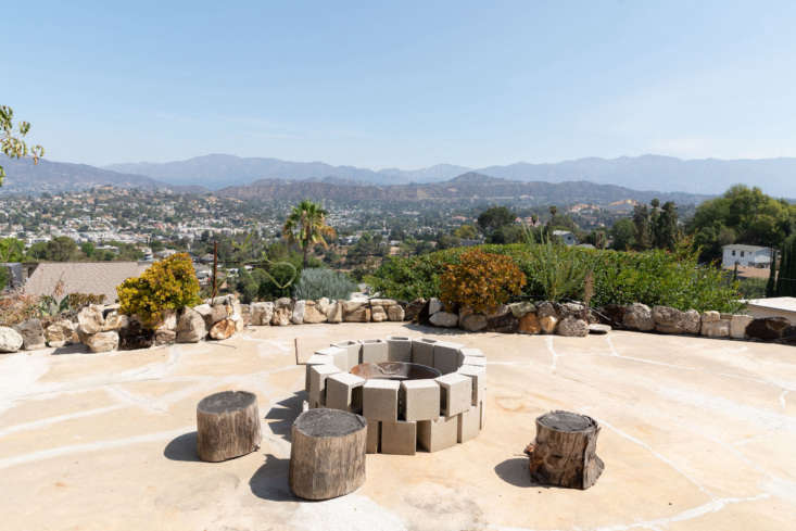 a cinder block formed firepit is surrounded by stumps turned stools. 23