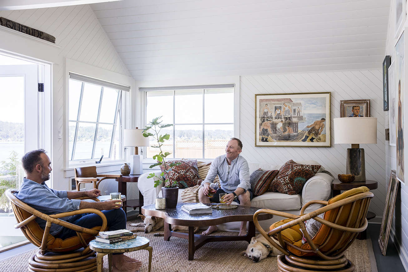 The couple and their dogs lounge in the sun room. Note the wood panels laid at an angle in this room.