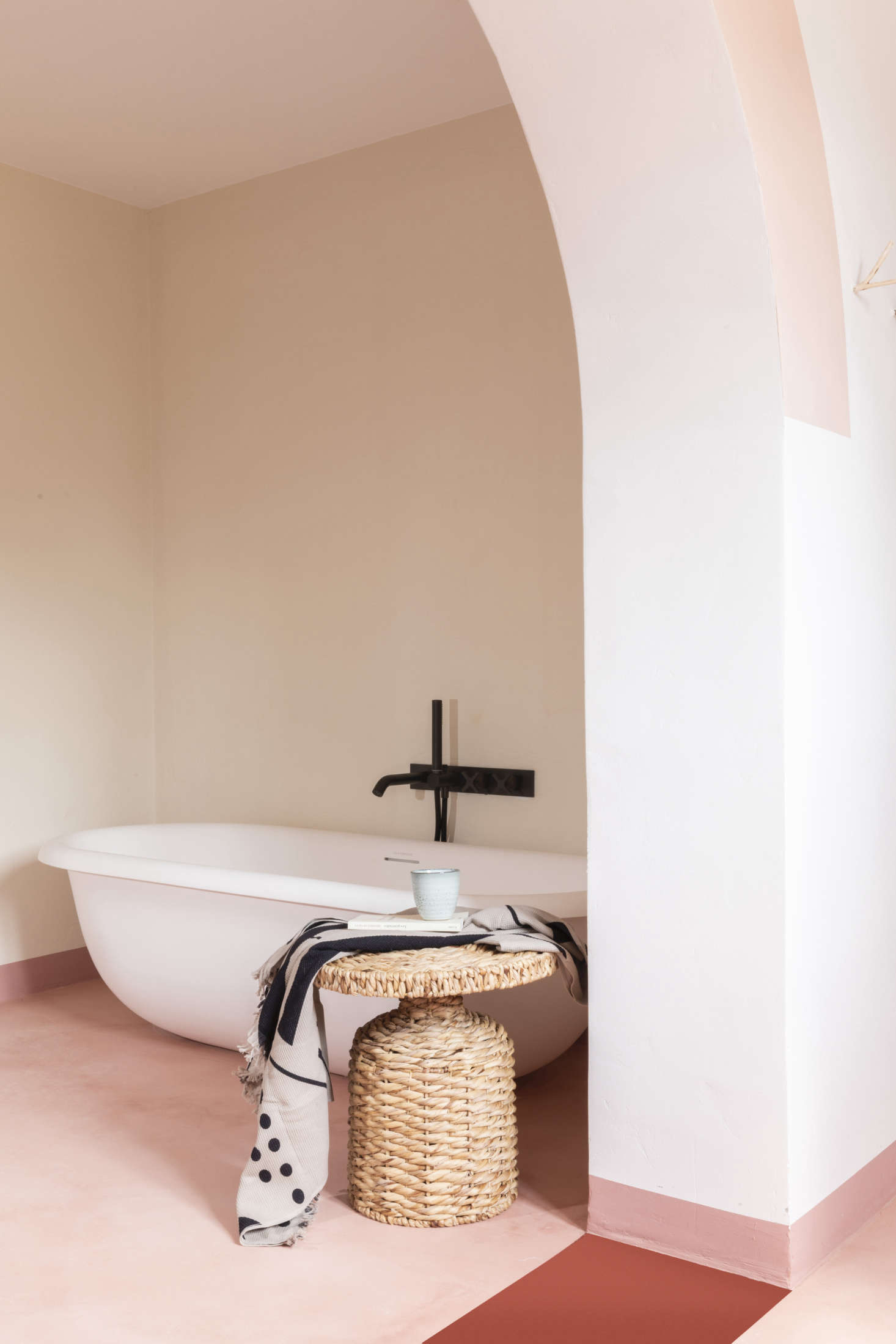 A freestanding modern tub, the Evolve Bath 50 from British company Claybrook, is set in its own niche. The two-toned floor is microcement.