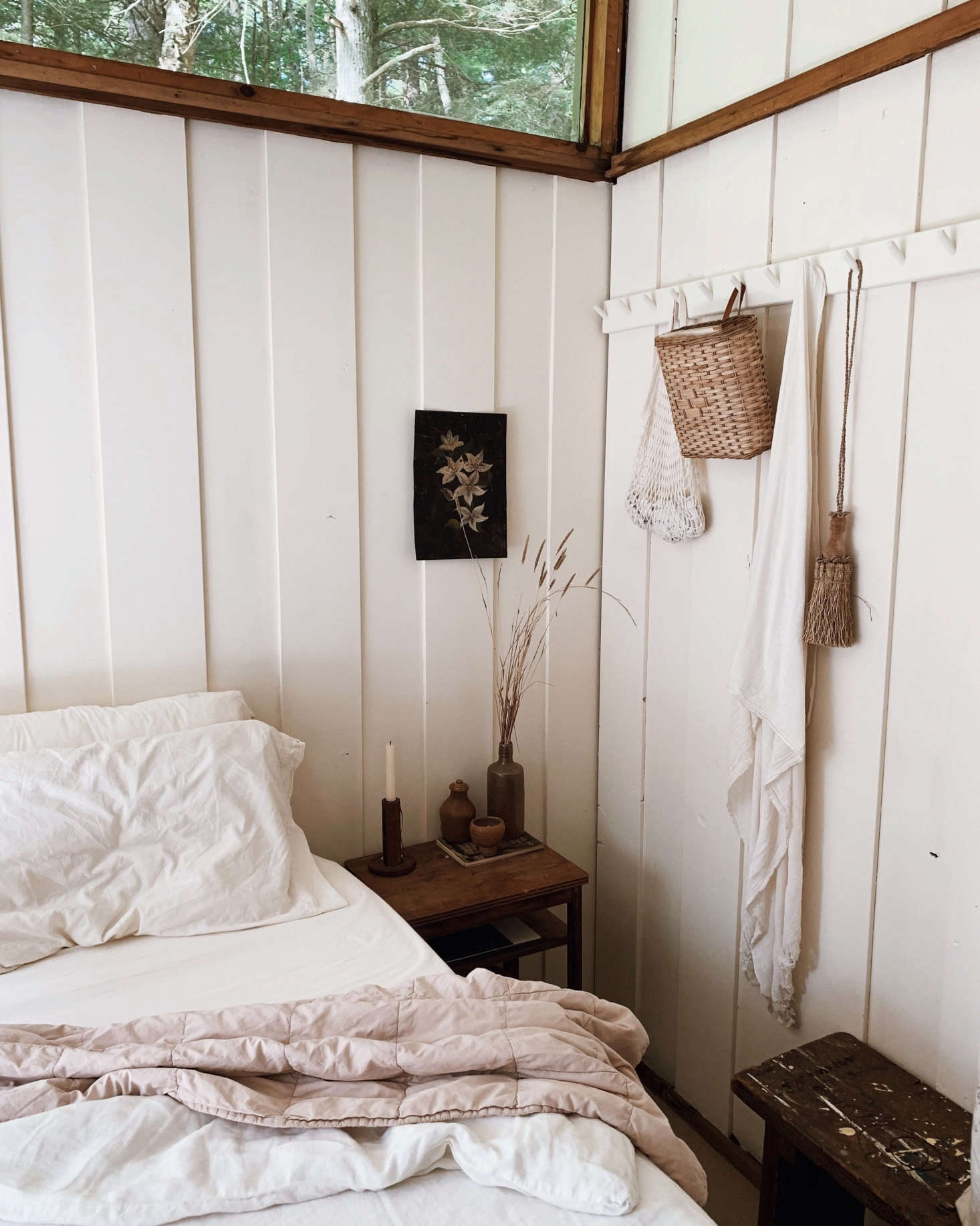 The bedroom is set for an off-the-grid weekend away, with bedside candlesticks collected from a nearby antique shop and a peg rail from The Foundry Home Goods.