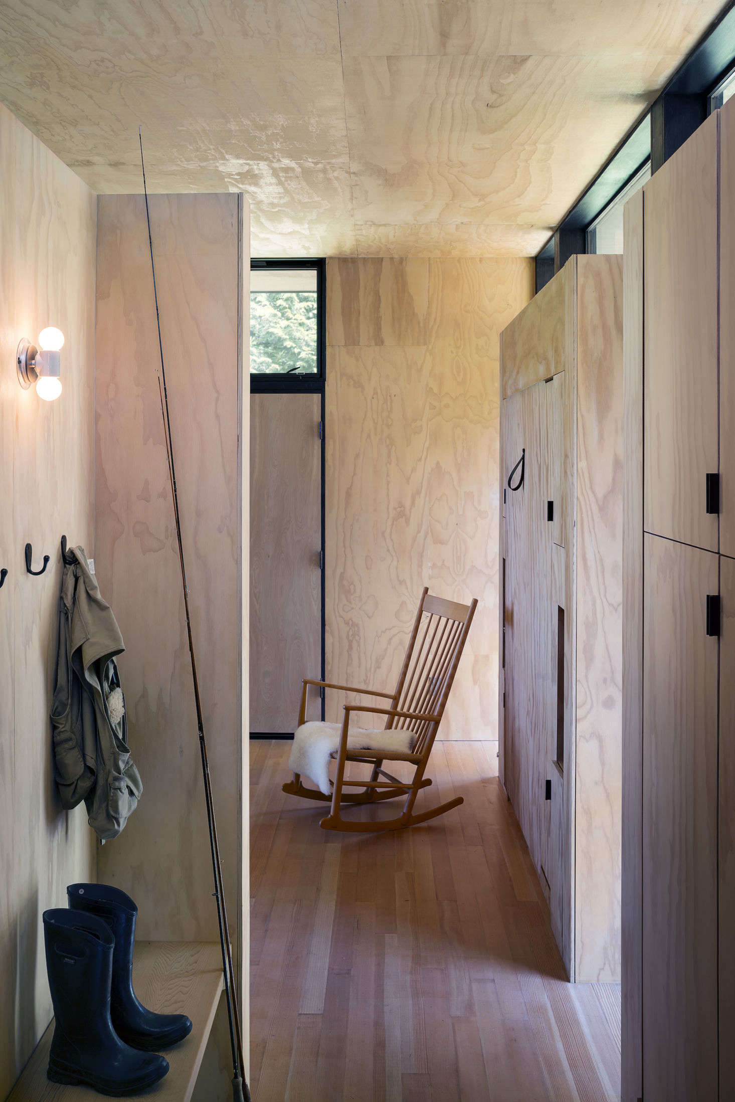 The entry into the main cabin. Just beyond is a Hans Wegner rocking chair and a hidden Murphy bed on the right wall of the living room. The flooring is fir hardwood, and the ceiling and walls are clad in pine plywood.