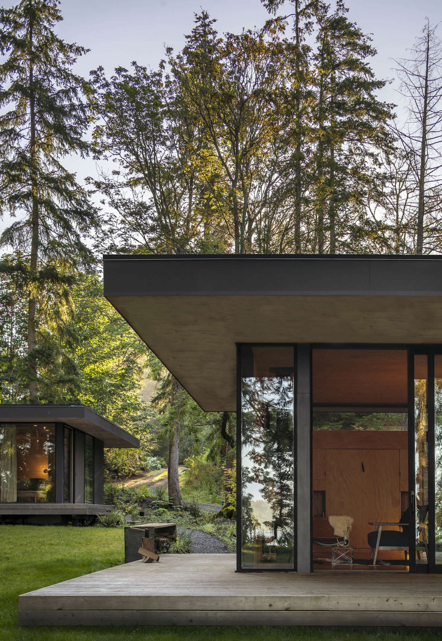 The main cabin is in the forefront, the bunkhouse in the back. The most dramatic feature of the buildings may be the large eaves of engineered wood. 