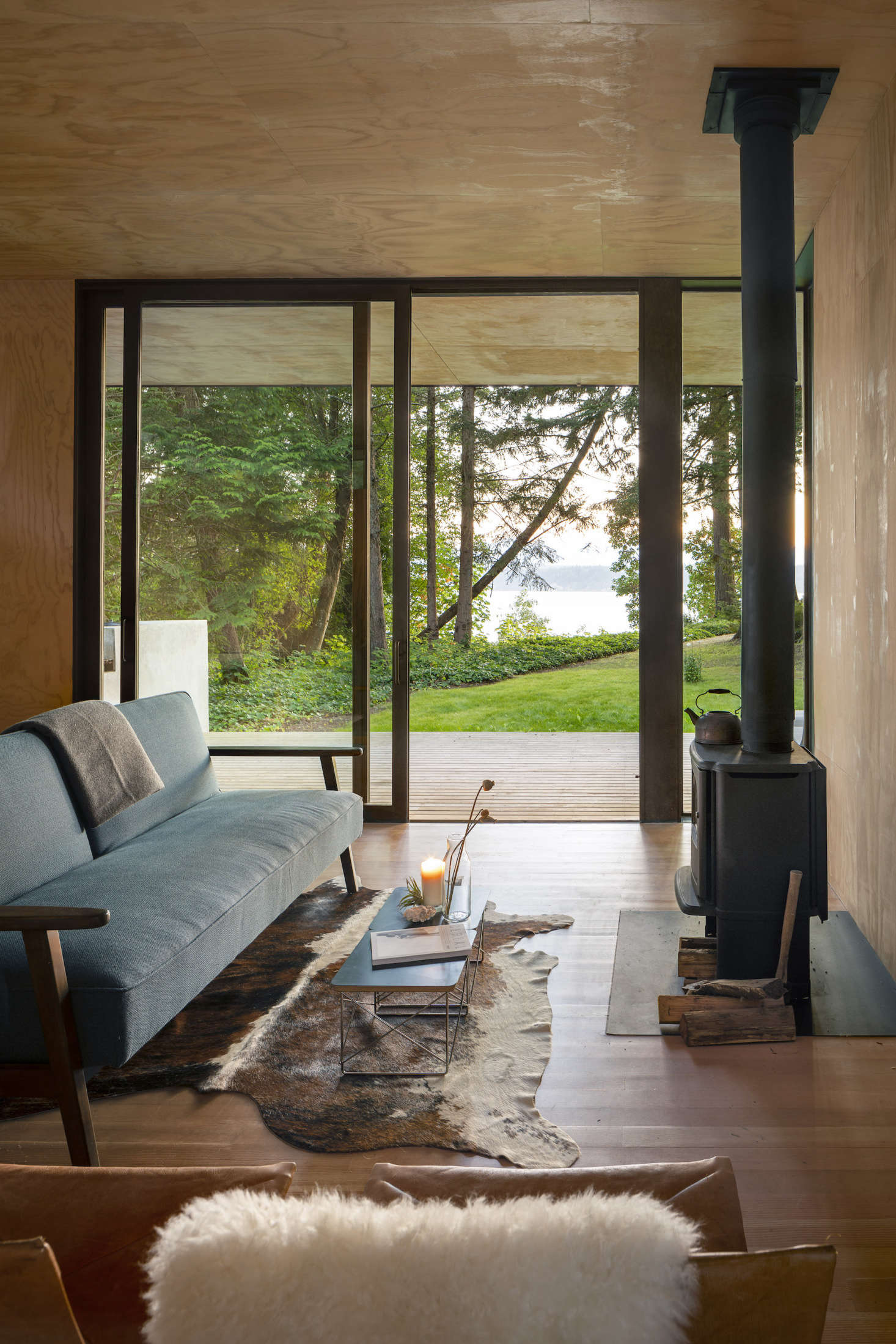 Mid-century furniture throughout reinforces simple, clean lines. The wood-burning stove is from Danish company Morsø; model 3440 is designed to be environmentally friendly. Ten-foot-high glass doors by Lindal ensure unimpeded views of the canal.