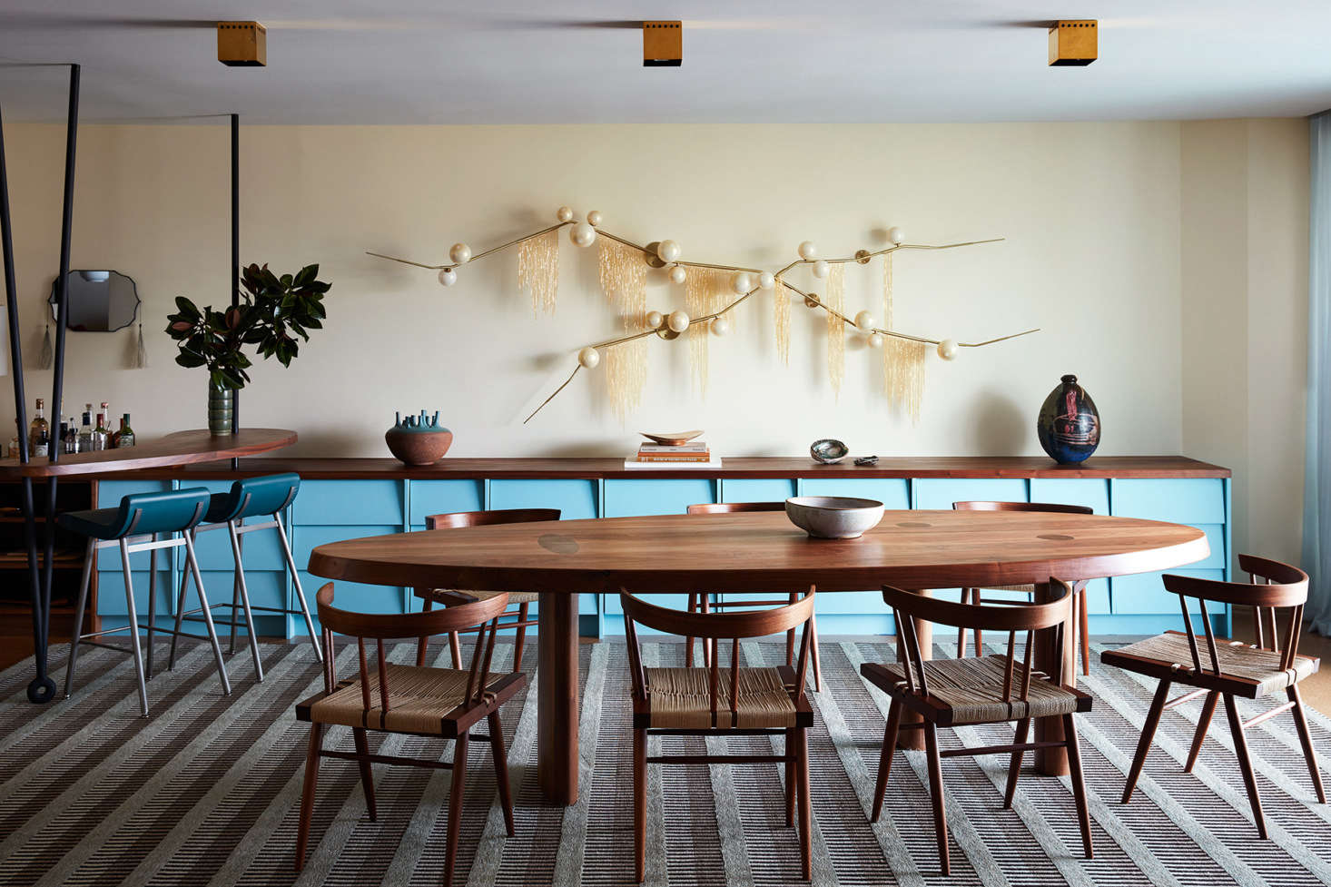 Adjacent to the kitchen is the dining area, with a Commune-designed console with attached bar. Surrounding the table are George Nakashima