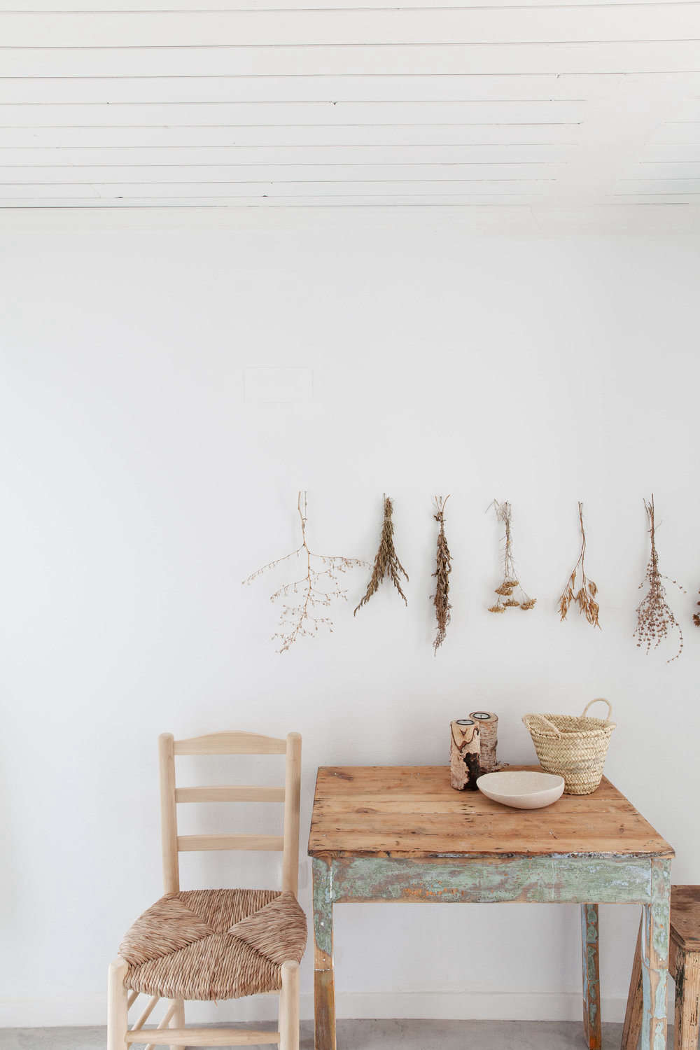 Bundles of dried flowers and stems make for a sweet vignette above a dining table.