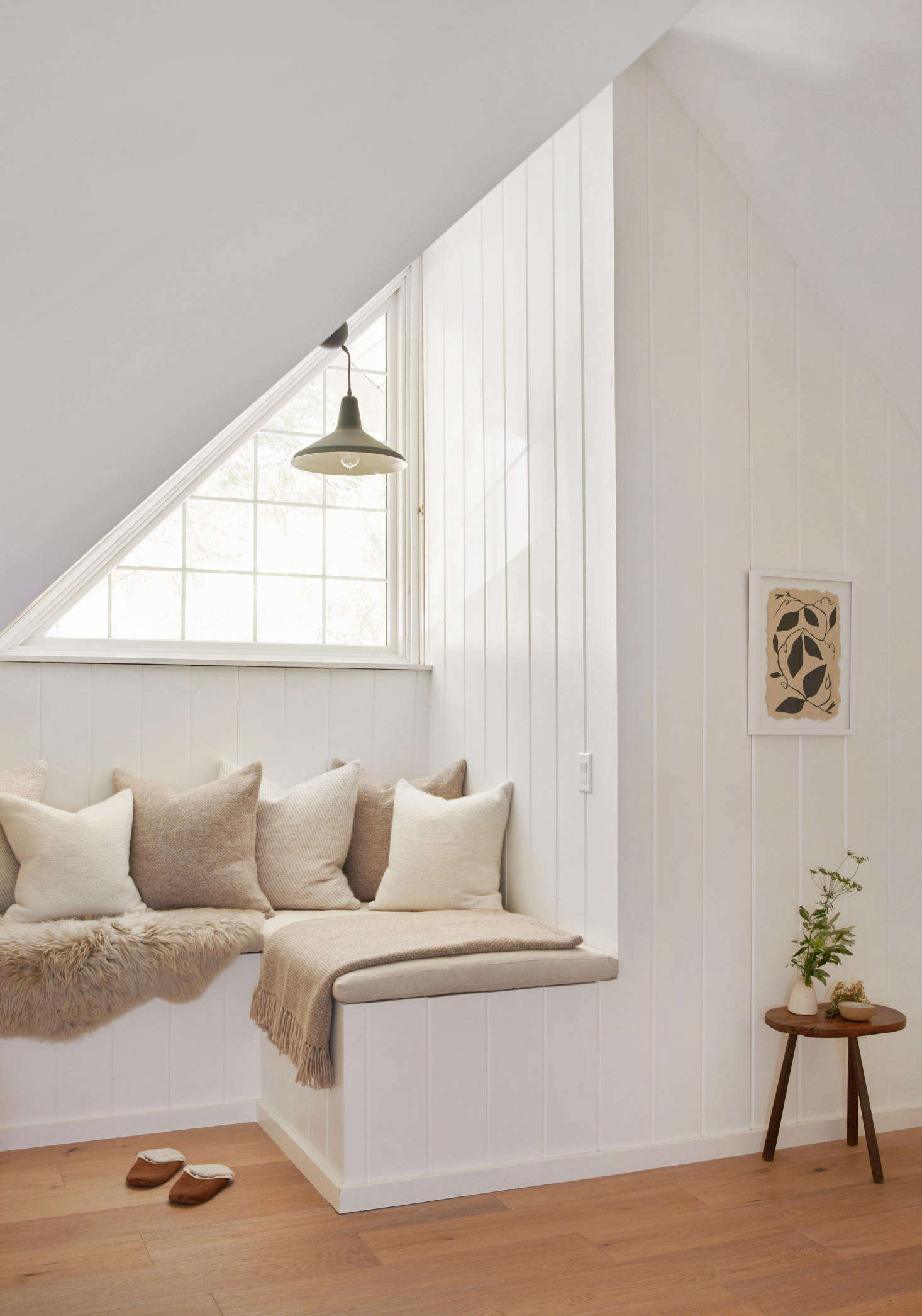 A built-in sitting area makes use of a nook beneath a window.