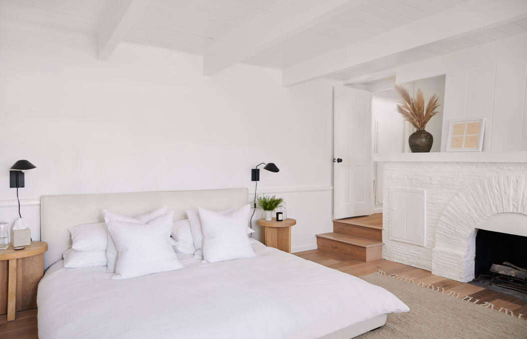 The ground-floor master bedroom and its original fireplace also got a fresh coat of white paint. Just off of the room are steps that lead directly down to the dock.
