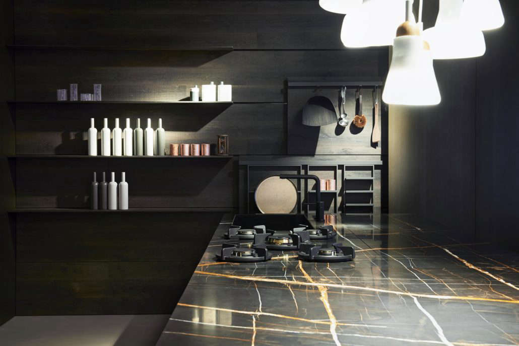 A kitchen by Key Cucine with a a black marble countertop and inset burners from Pitt.