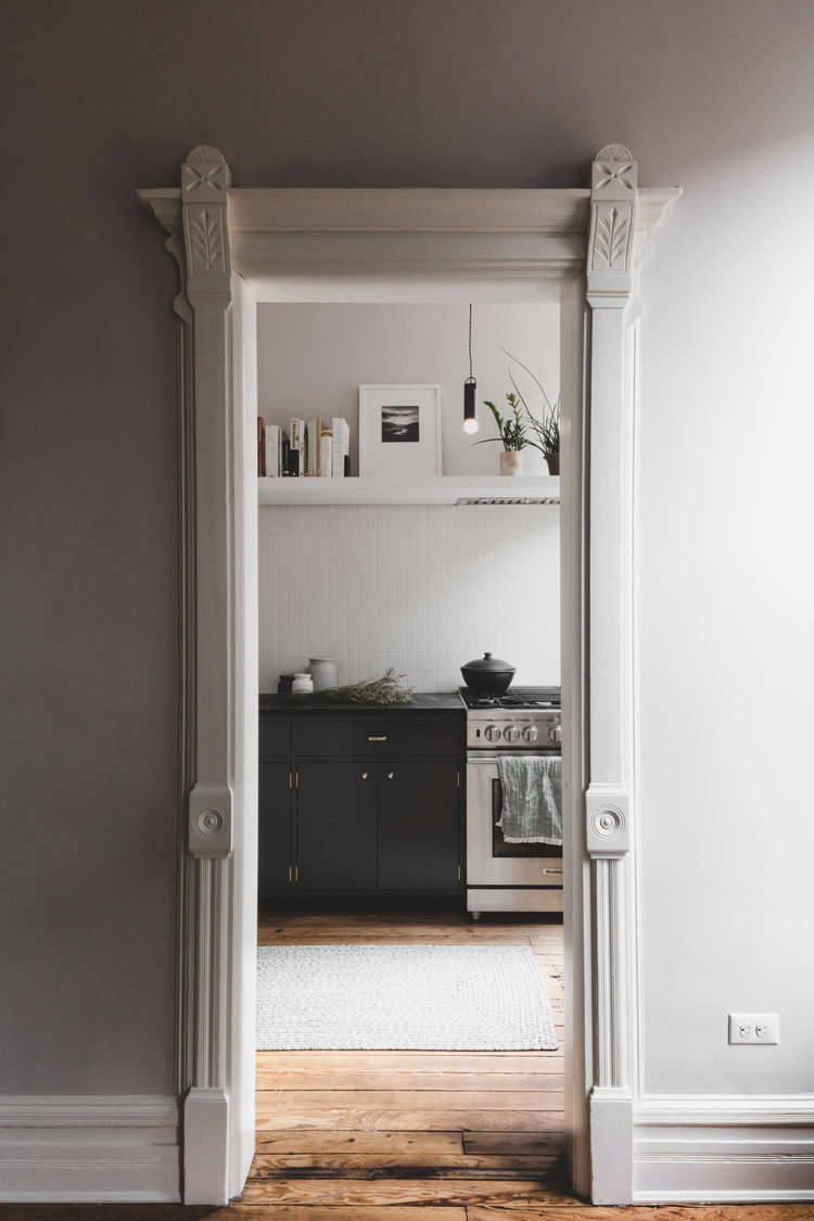 The couple added a kitchen to the parlor floor, framed here by moldings painted Benjamin Moore