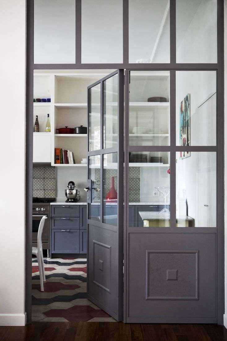 the studio created an iron and glass door between the kitchen and living room.  17