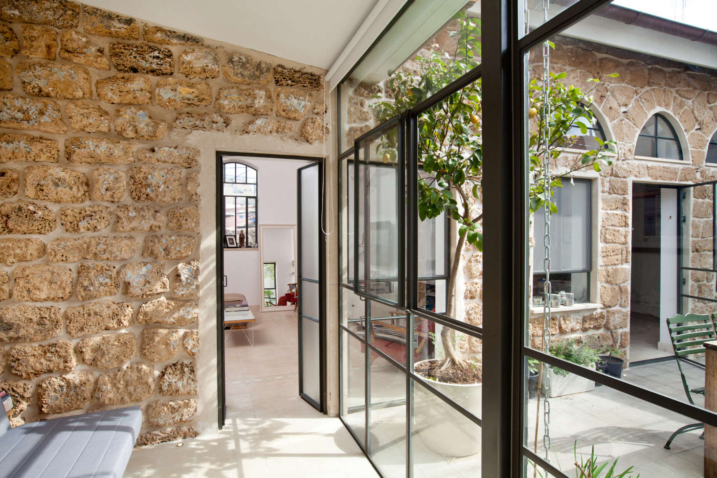 Another glass and steel wall makes the interiors feel like an extension of the courtyard..