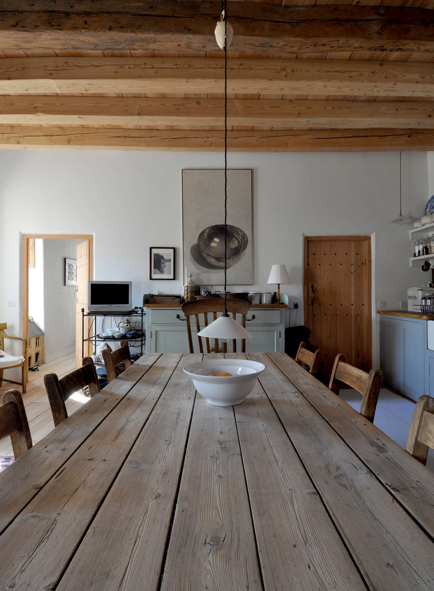 The antique dining table was originally used in the ironing room of a laundry facility.