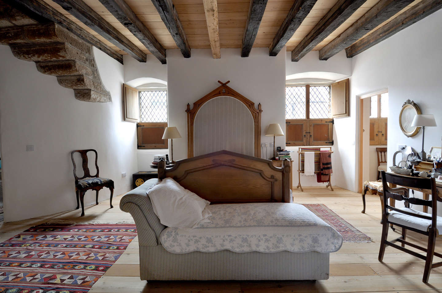The main bedroom features an antique bed and colorful kilims.