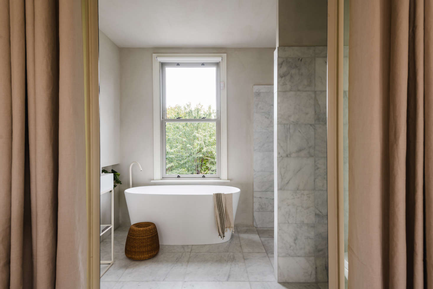 Large Calacatta marble tiles on both the floor and the walls.
