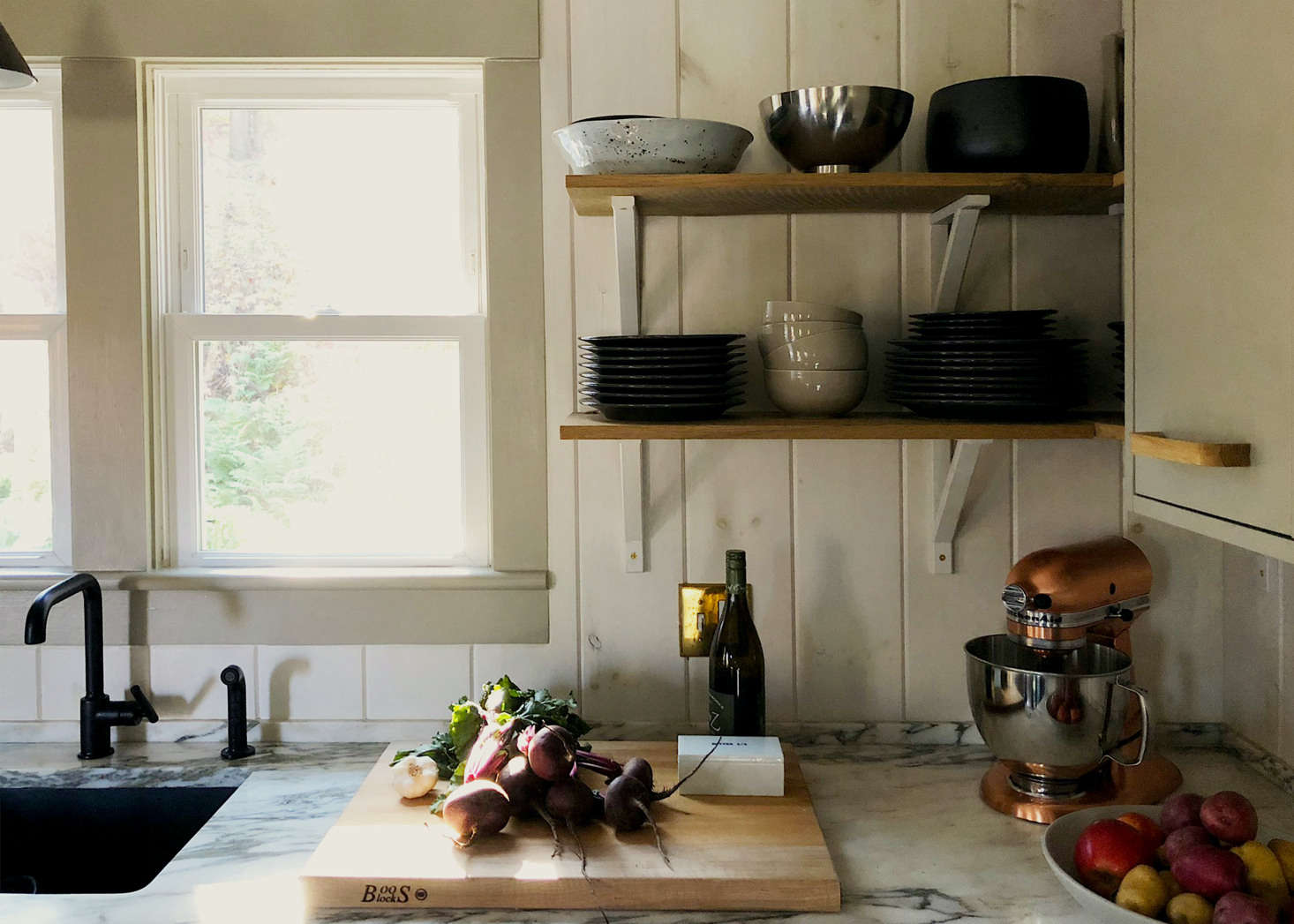 The splurge: to add nuance and texture, the counters are Calacatta Tucci marble from Stone Source and the back and entry wall have whitewashed V-groove pine paneling Charlie installed himself.