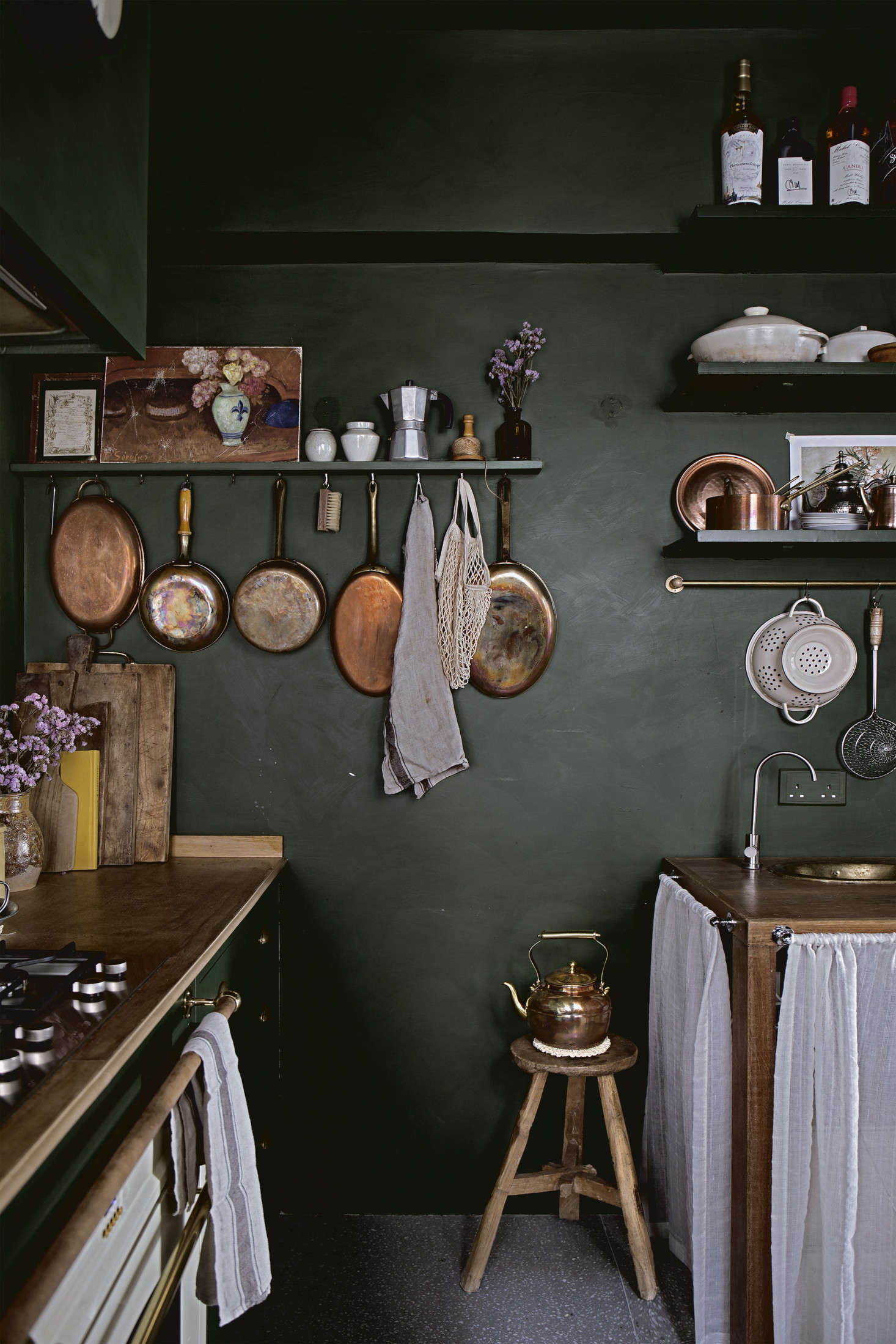 Mandy displays most of her cookware on hooks. Behind the sink skirt are 