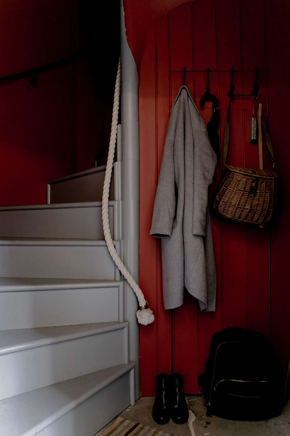 A winding staircase with a rope rail greets guests. The walls here are painted Terre d