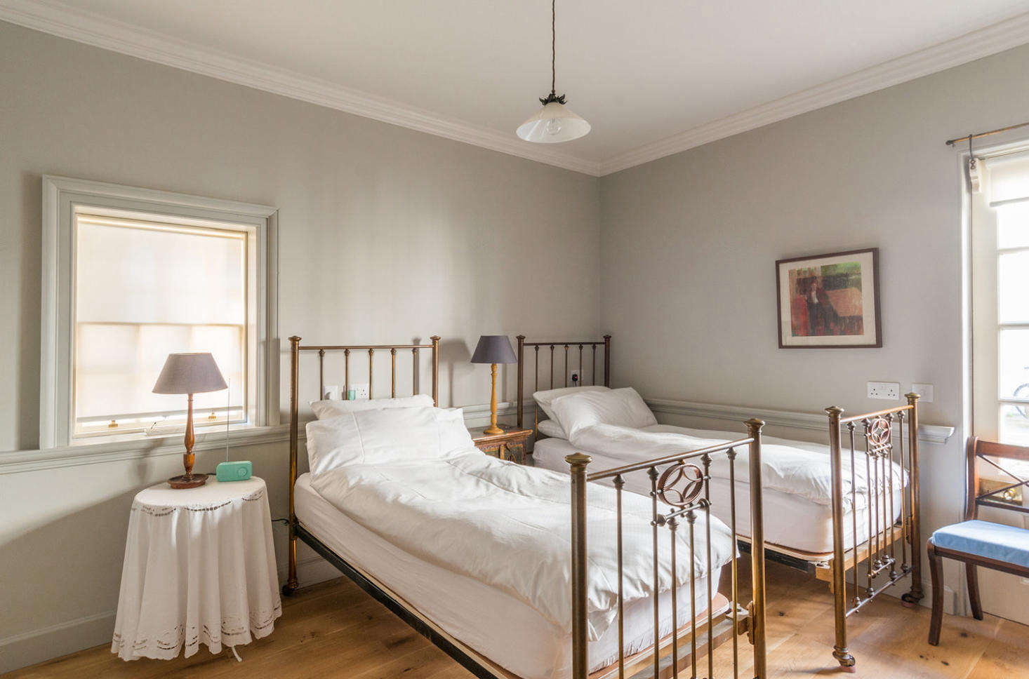 The house has a surprising layout, with the three bedrooms on the lower two floors and the living room and kitchen on the top floor. This guestroom, on the ground floor, features walls painted Pavilion Gray.