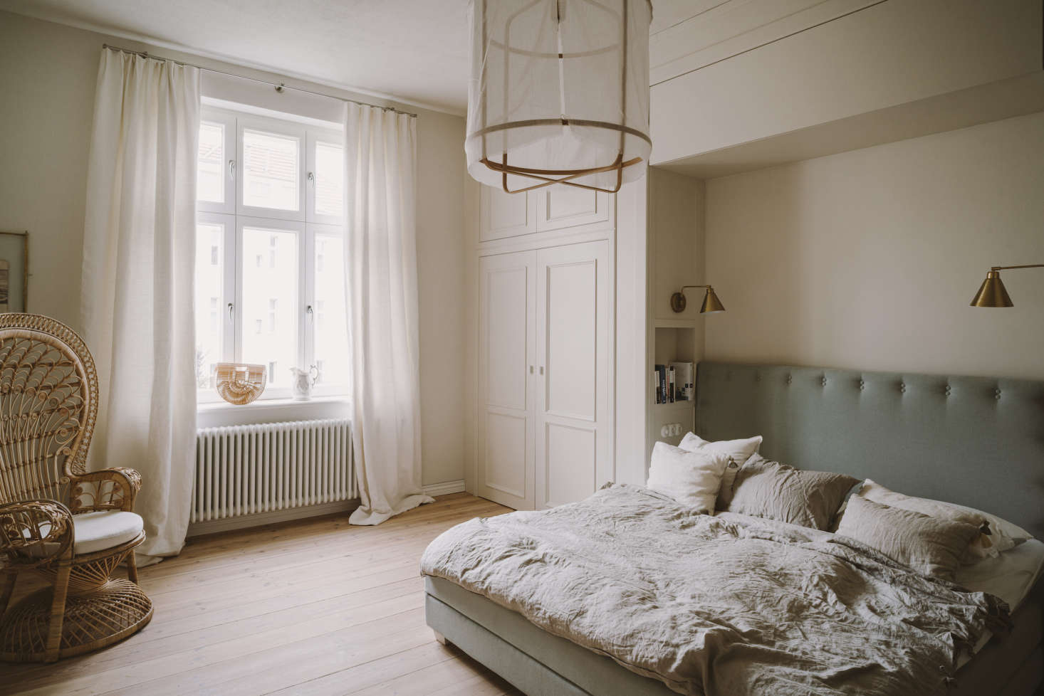 The master bedroom, anchored by a large bed with a headboard upholstered in Villa Nova