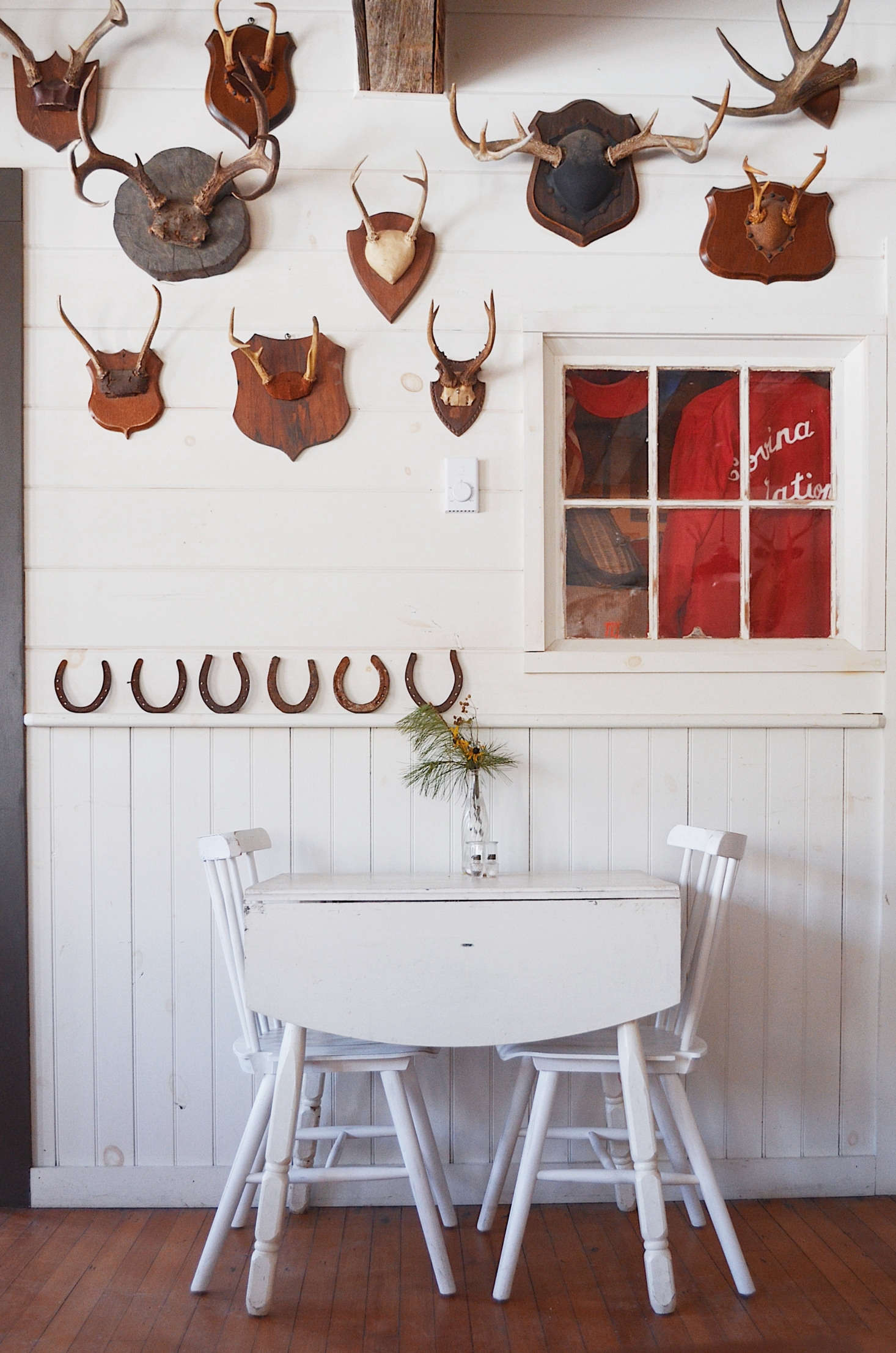 A painted table for two at the Red Rose tavern. The collection of mounted antlers were gathered over time on Craigslist.