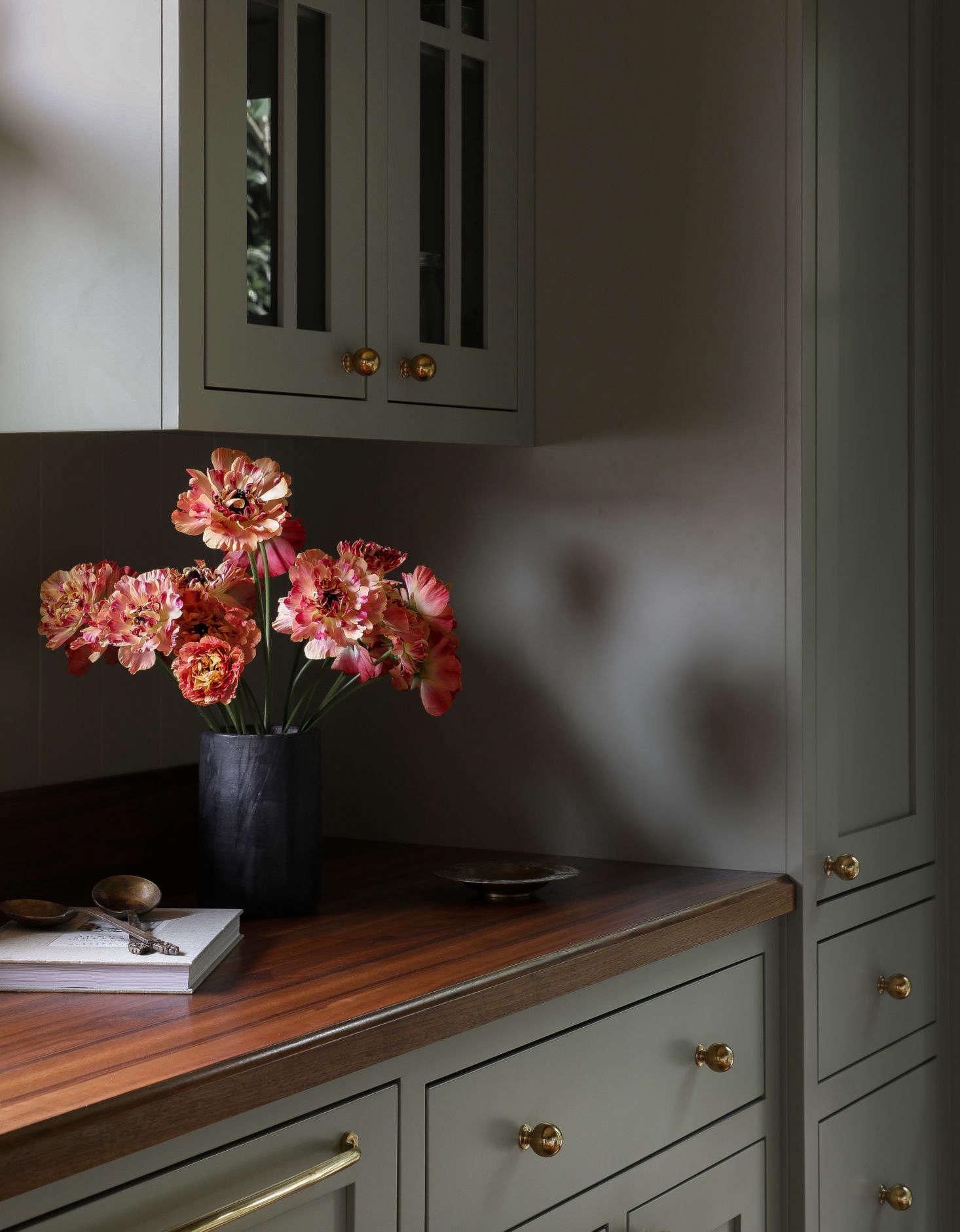 The fridge is integrated behind cabinet panels at the end of the range wall.